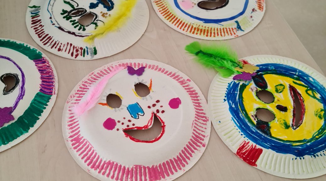 Kinder bemalen gemeinsam Pappteller mit bunten Farben