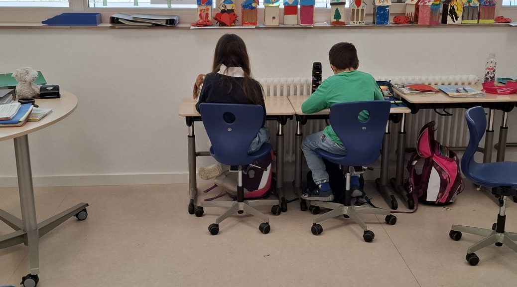 Grundschulkinder lernen gemeinsam an einem Gruppentisch