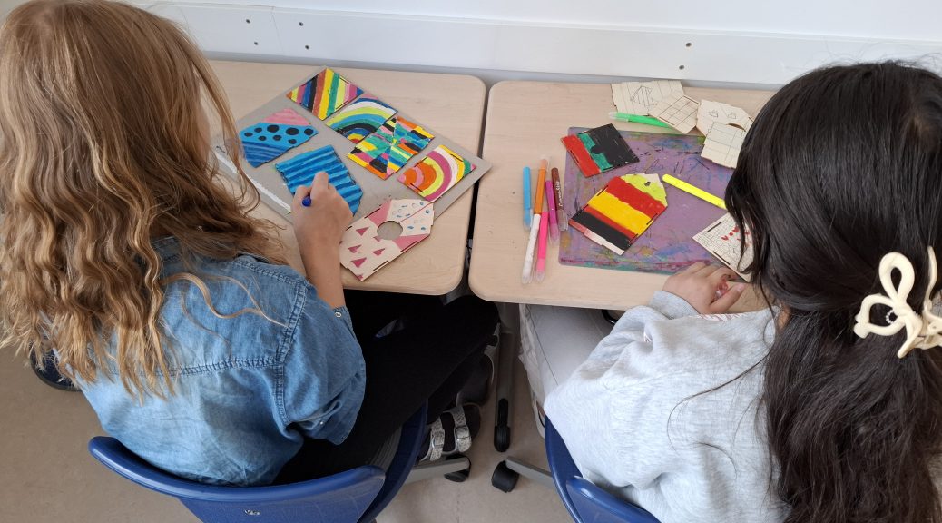 Kinder der Grundschule malen gemeinsam an einem Projekttisch